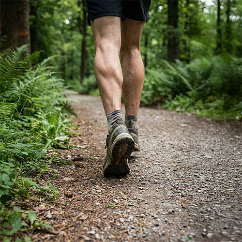 Mand i løbesko bevæger sig på skovsti.